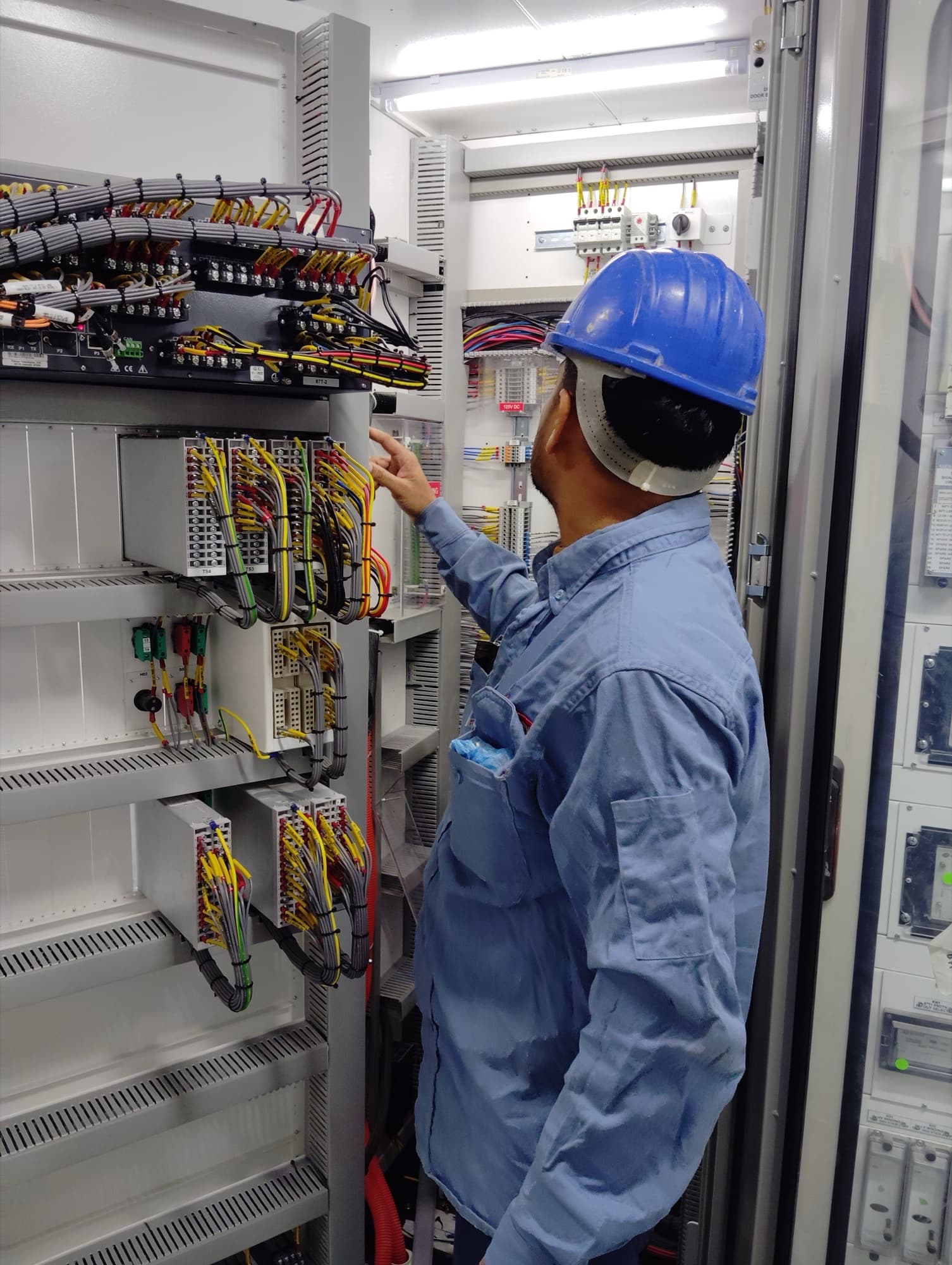 Electrician checking wiring in a distribution cabinet